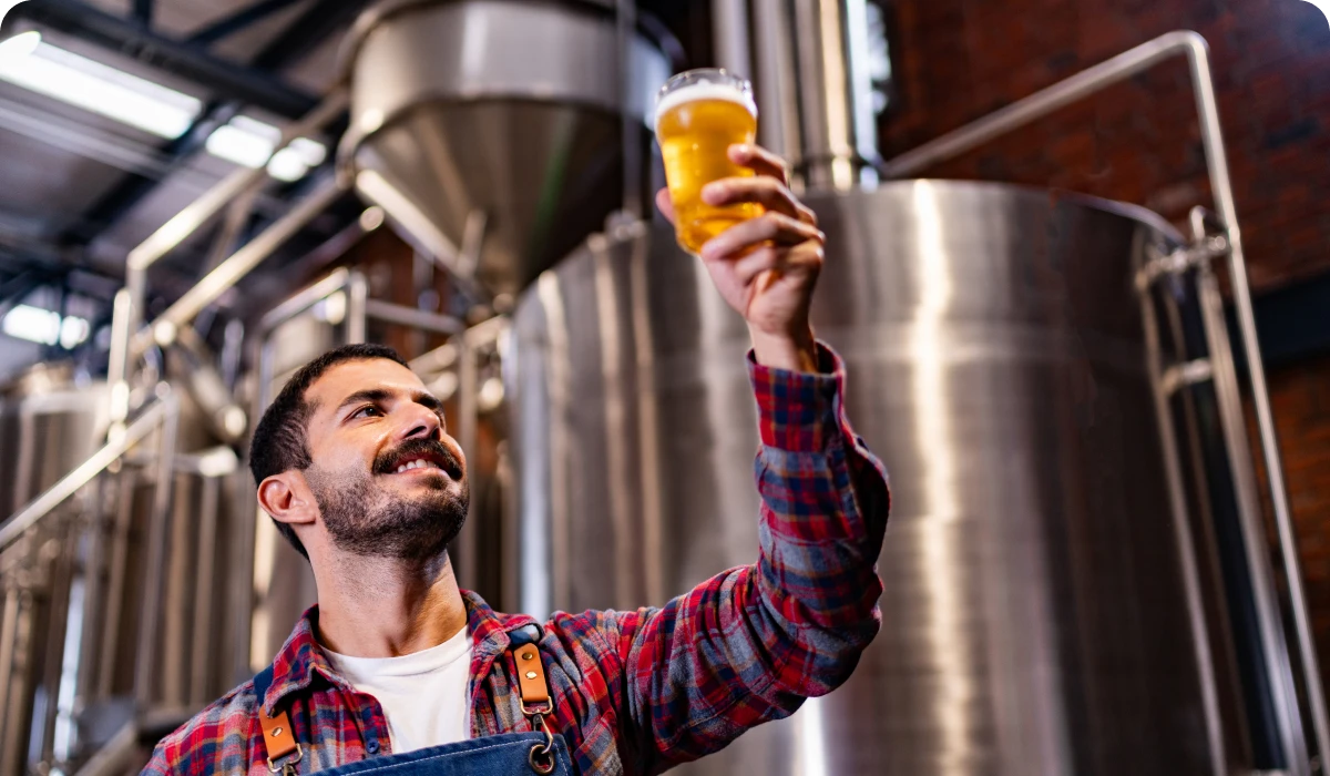 Man inspecting beer in a brewery.