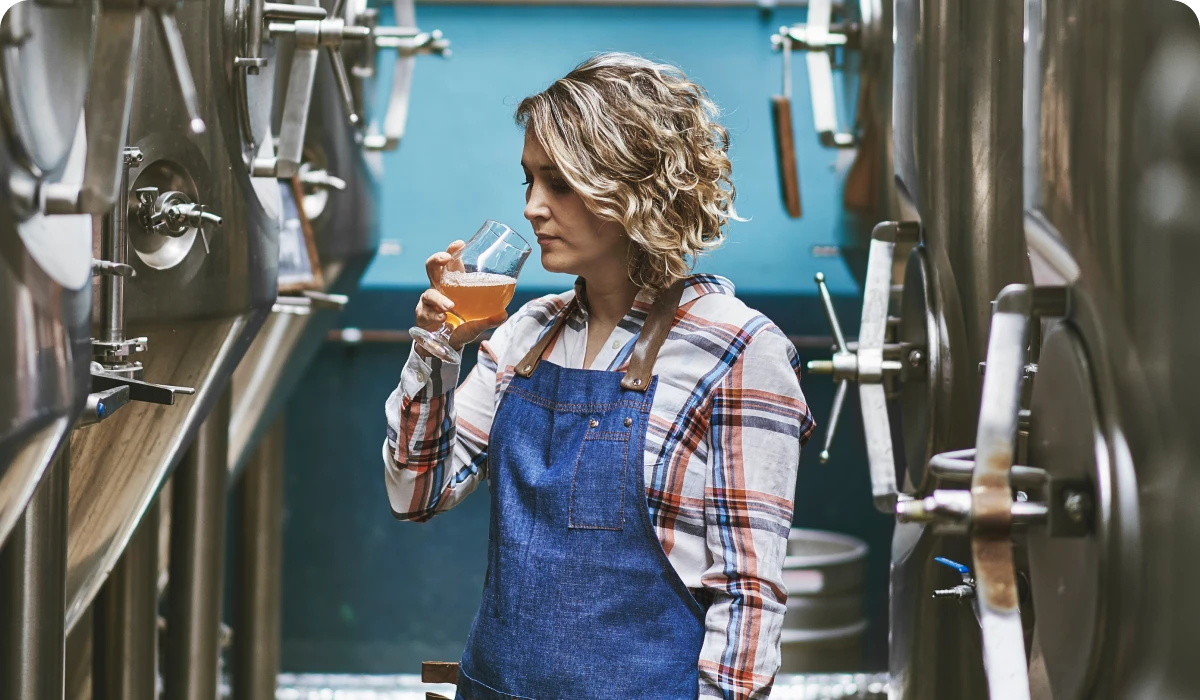 Woman tasting beer in brewery.