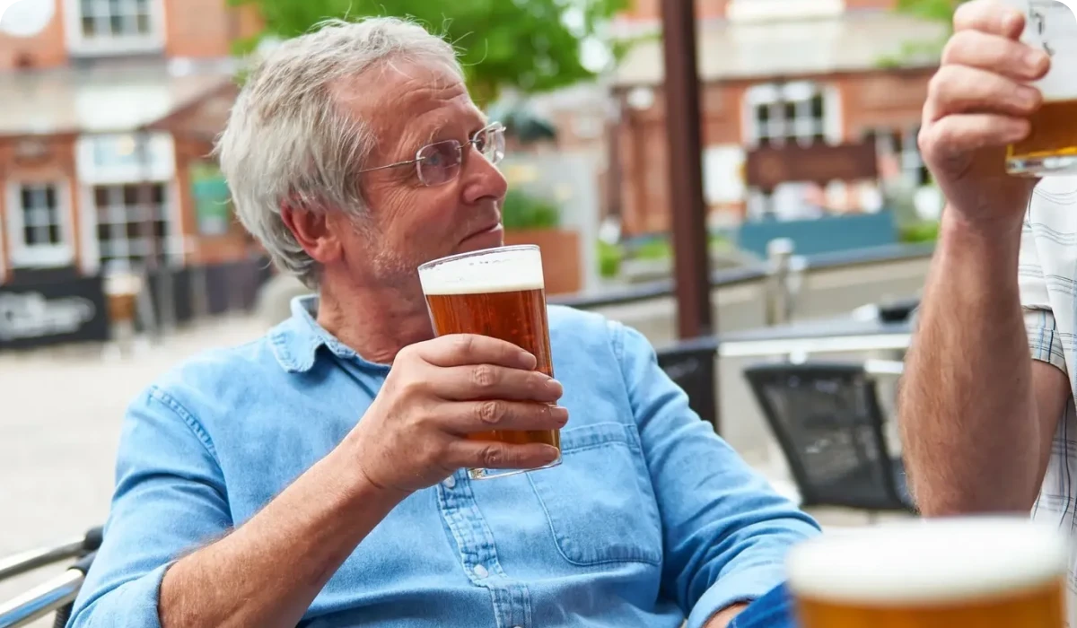 Man enjoying a beer outdoors with friend.